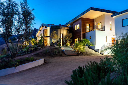 a modern home’s exterior and driveway area at dusk.