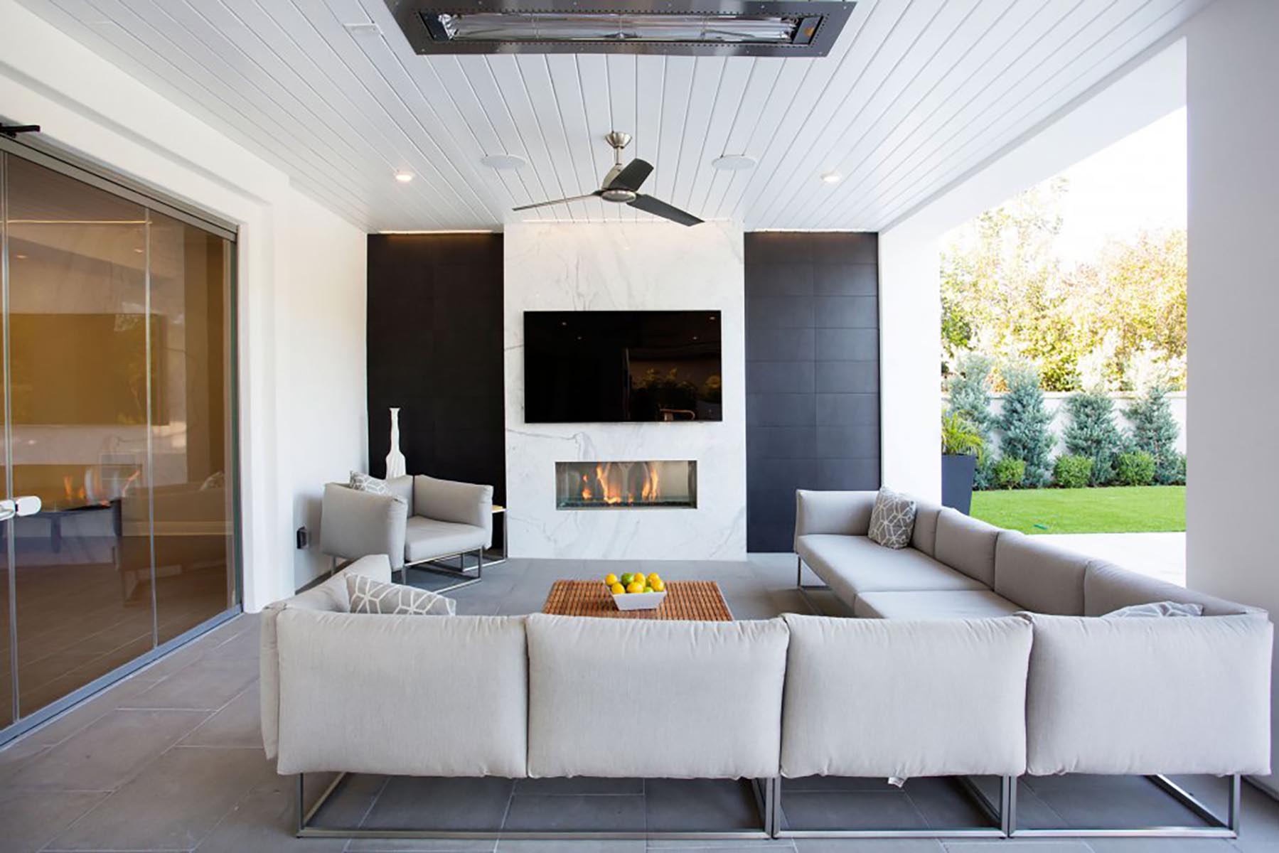 a modern remodeled outdoor living area with a gray couch.